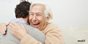 Elderly men hugging a young man